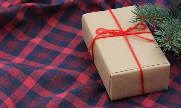 Kerst Nieuwjaarscadeau Verpakt Inpakpapier Gebonden Met Rood Touw Een Geblokt — Stockfoto