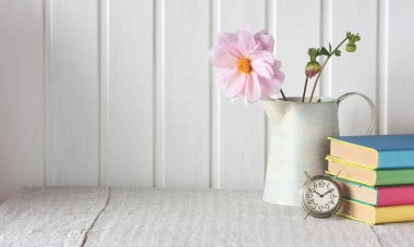 Okula dönüyorum. Masanın üzerinde ders kitapları ve çalar saat olan hafif kompozisyon. Boşluğu kopyala.