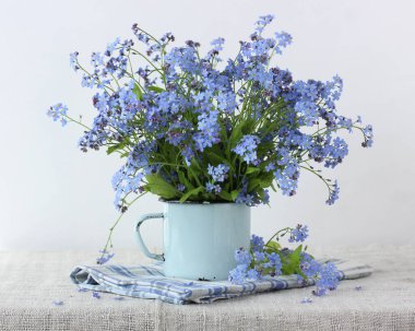Mavi bir fincanda bir buket unutma beni. hassas yaz kompozisyonu.