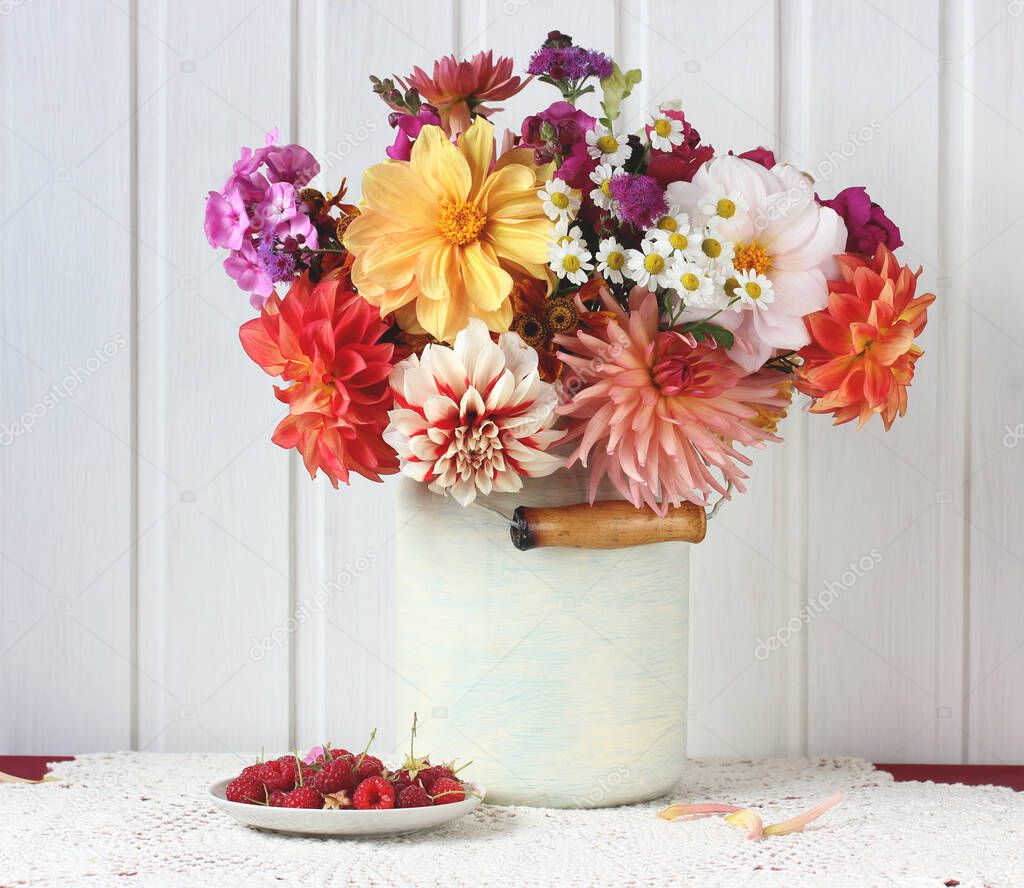 dahlias and raspberries. flowers and berries. light still life in a rustic style.