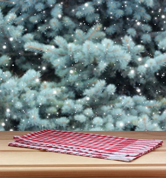 Egy Üres Asztal Törülközővel Homályos Téli Háttérrel Fenyőágakkal Hóeséssel — Stock Fotó