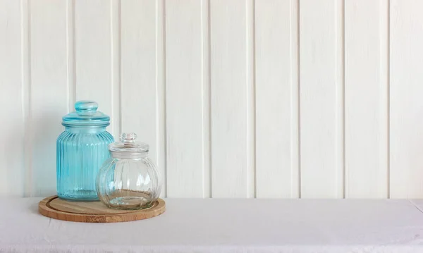 Two Glass Jars Table White Tablecloth Wooden Wall Empty Background — Stock Photo, Image