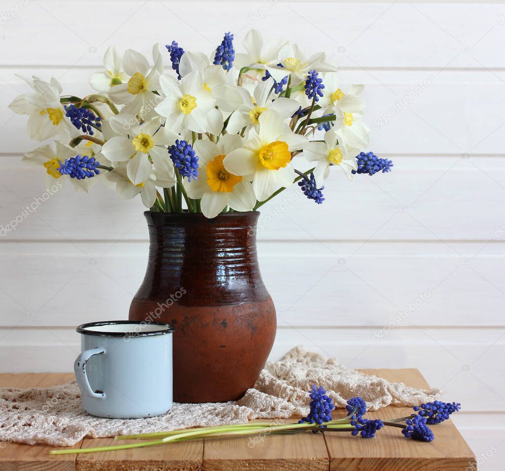 bouquet of spring flowers in a clay jug. daffodils.
