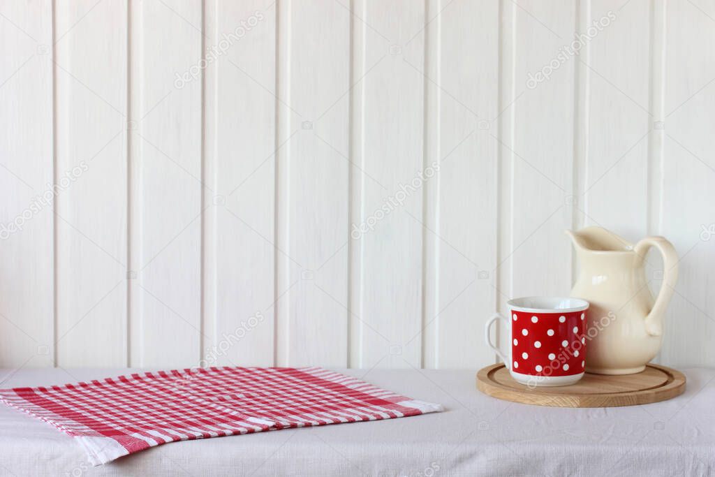 rustic mockup with a towel and dishes on the table. red and white background. empty space for your object.