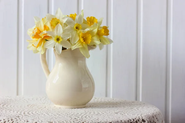 Žluté Bílé Narcisy Džbánu Stole Krajkovým Ubrusem Jasná Jarní Zátiší — Stock fotografie