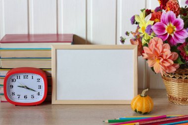 Okul maketi. Okula dönüyorum. boş bir çerçeve, bir buket yıldız çiçeği, bir çalar saat ve masanın üzerinde ders kitapları. Metnin için boş yer. 1 Eylül, bilgi günü.