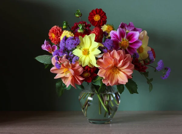 明亮的花园大丽花花束 花在玻璃瓶中 在桌子上深绿色的背景上 — 图库照片