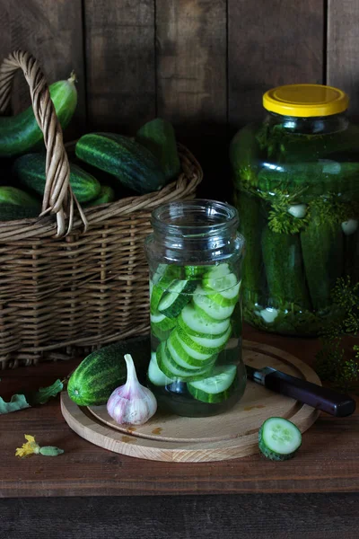 家庭の野菜をテーブルの上のガラス瓶で軽く塩キュウリで漬ける準備ができている緑のキュウリ — ストック写真