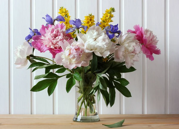 Frühlingsblumen Einer Glasvase Pfingstrosen Und Schwertlilien Auf Einem Holztisch — Stockfoto