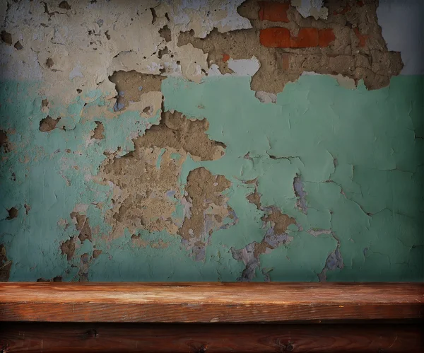 Wooden table against an old wall — Stock Photo, Image