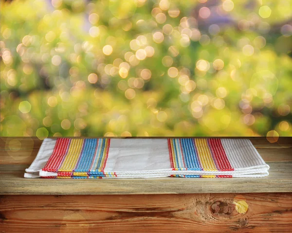 Houten tafel met een handdoek tegen een kant — Stockfoto