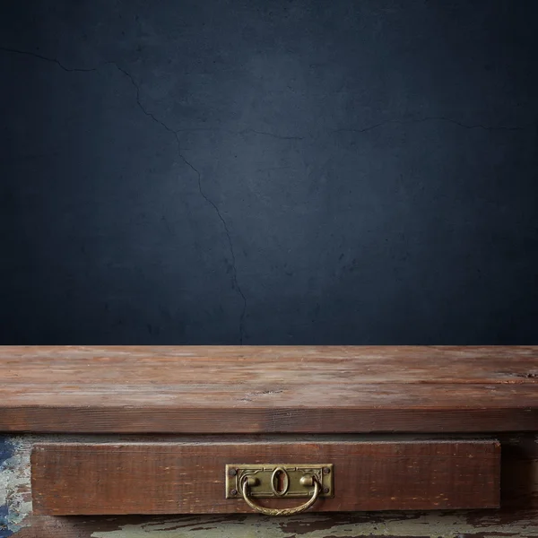 Bir kutu eski bir mavi duvar karşı boş ahşap masa.