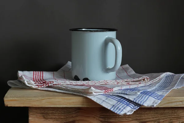 Becher und Handtuch auf einem Holztisch — Stockfoto