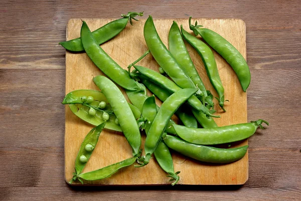 Green peas on a table, the top view. — Stock Photo, Image