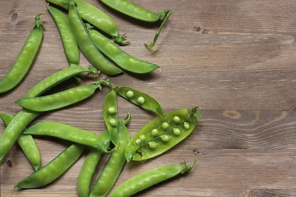 Green peas on a table, the top view. — Stock Photo, Image