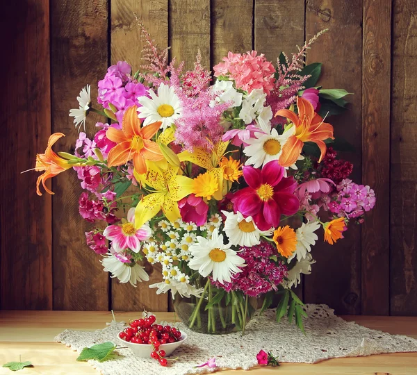 Bouquet from cultivated flowers in a jug. — Stock Photo, Image