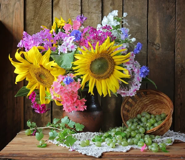 Stillleben mit einem Strauß Sonnenblumen und Phloxen. Blumen und Beeren. — Stockfoto