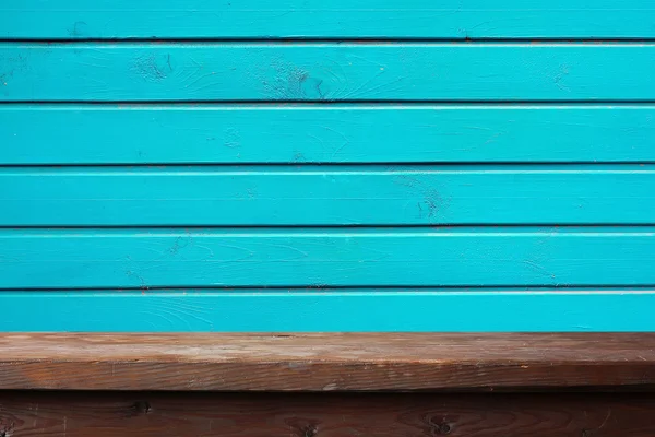 Lege houten tafel tegen een muur van boards. — Stockfoto