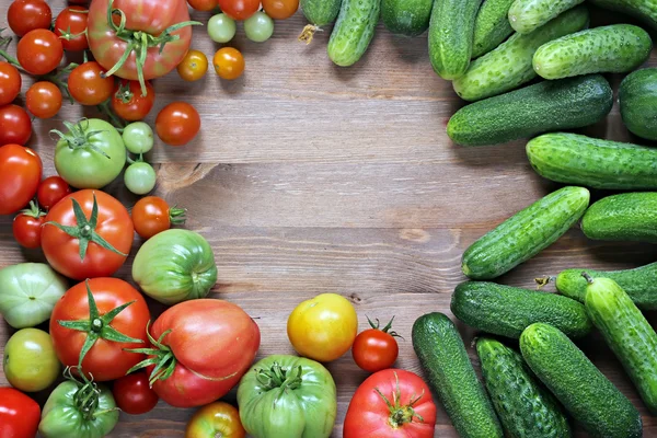 Fresh cucumbers, red and green tomatoes on a table 
