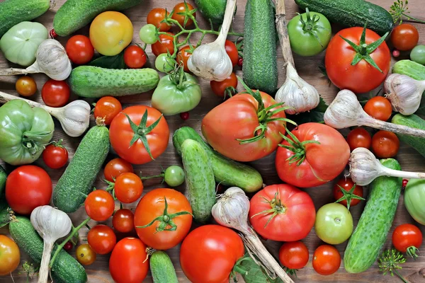 Färsk gurka, vitlök, röd och grön tomater på ett bord. — Stockfoto