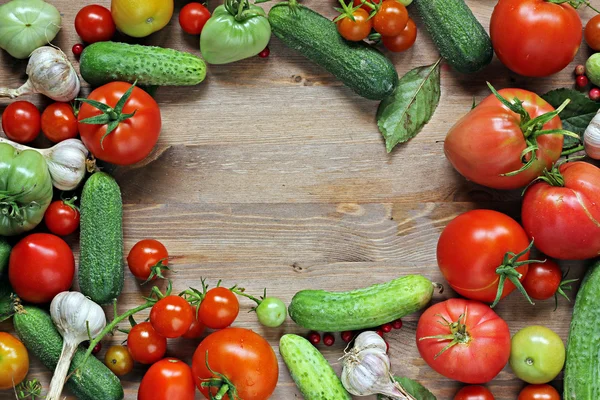 Los pepinos frescos, el ajo, los tomates rojos y verdes sobre la mesa . —  Fotos de Stock