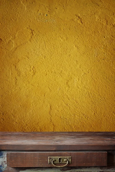 Empty table against a wall with yellow plaster. — Stock Photo, Image