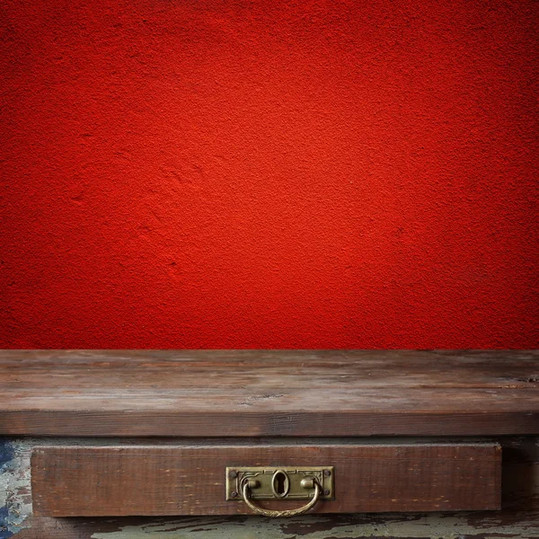 Empty wooden table against a red  wall. — Stock Photo, Image