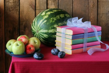 Still life with books, plums, a water-melon and apples clipart