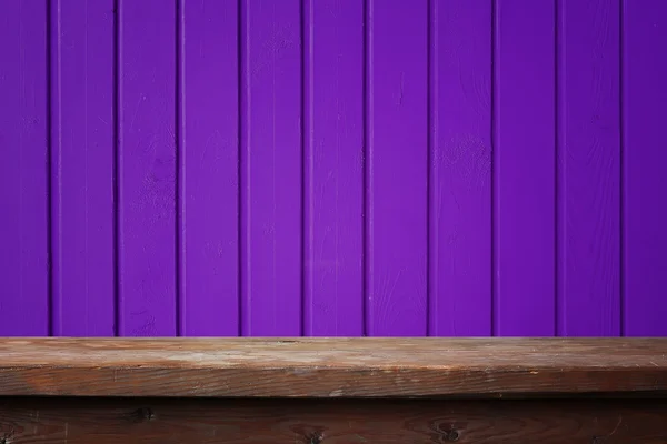 Tom träbord mot en violett vägg. Royaltyfria Stockfoton