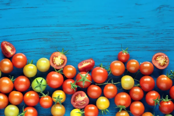 Tomates cherry maduros sobre fondo azul —  Fotos de Stock