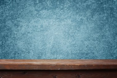 boş ahşap masa mavi bir duvara karşı.