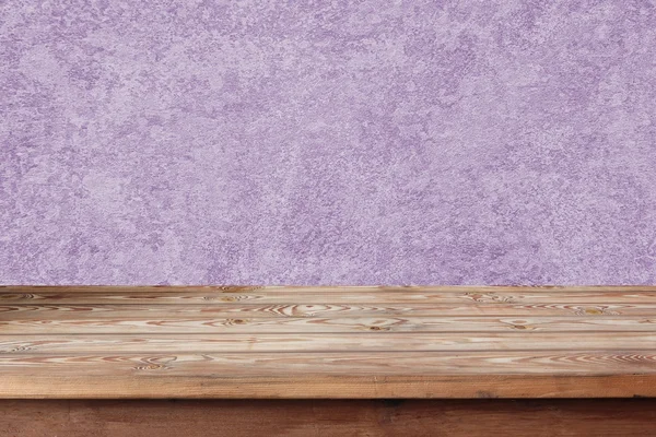 Empty wooden table against a lilac wall. — Stock Photo, Image