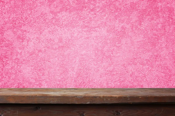 Mesa de madeira vazia contra uma parede rosa . — Fotografia de Stock