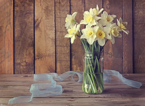 Still life with narcissuses in a glass jar — Stock Photo, Image