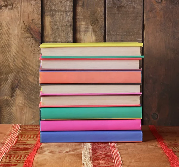 Stapel boeken op een tabel met een rood doek — Stockfoto