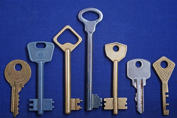 Tasten auf blauem Hintergrund. Sieben Schlüssel. — Stockfoto