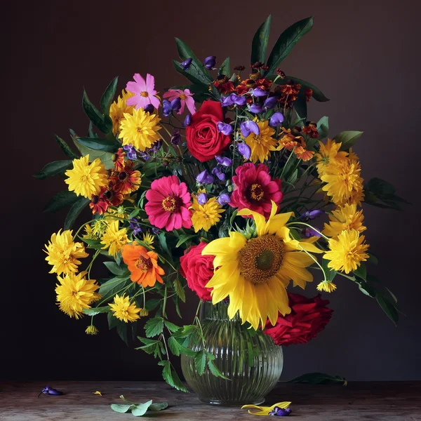 Şeffaf bir büyük karınlı sürahi bir buket ile natürmort