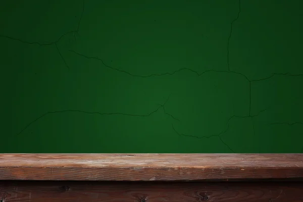 Leerer Holztisch vor grüner Wand — Stockfoto