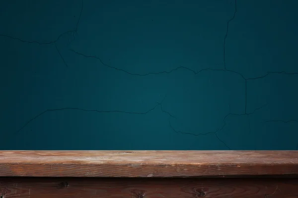 Leerer Holztisch vor blauer Wand — Stockfoto