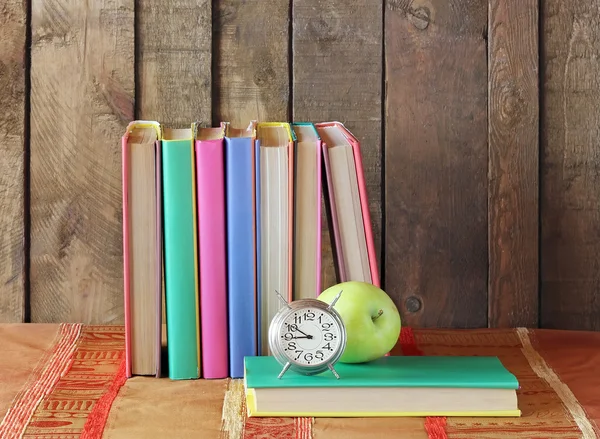 Bodegón con libros, manzana y despertador . — Foto de Stock