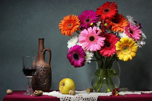 Nature morte avec marguerites Transvaal, pommes et vin rouge . — Photo