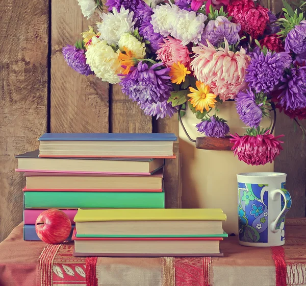 Stillleben mit Büchern und einem Strauß Astern. — Stockfoto