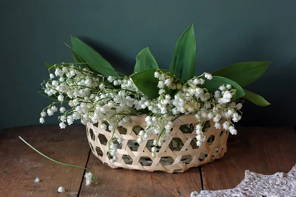 Still life with lelies van de vallei in een mand. — Stockfoto