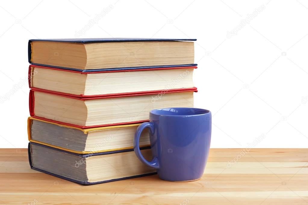 A stack of books and a Cup  on table, on a white background.