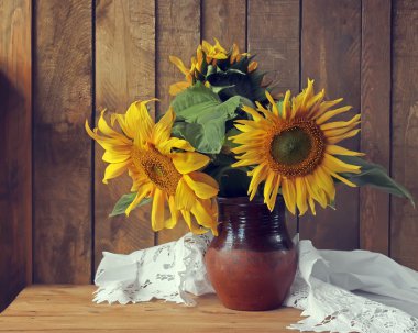 Natürmort ayçiçeği bir kil sürahi içinde bir buket.