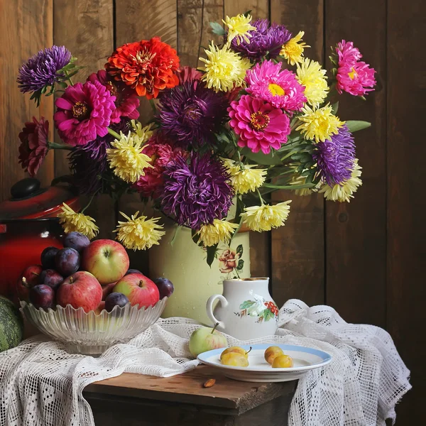 Nature morte avec un bouquet d'automne, pommes et prunes . — Photo