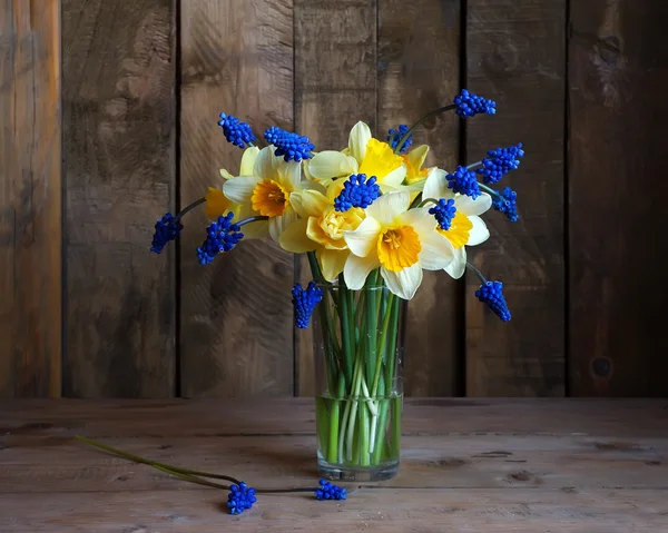 Still life with a bouquet of yellow narcissuses in a transparent — Stock Photo, Image