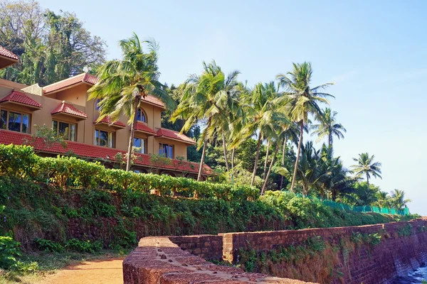 El edificio del hotel con palmeras en una costa del océano en la India . — Foto de Stock