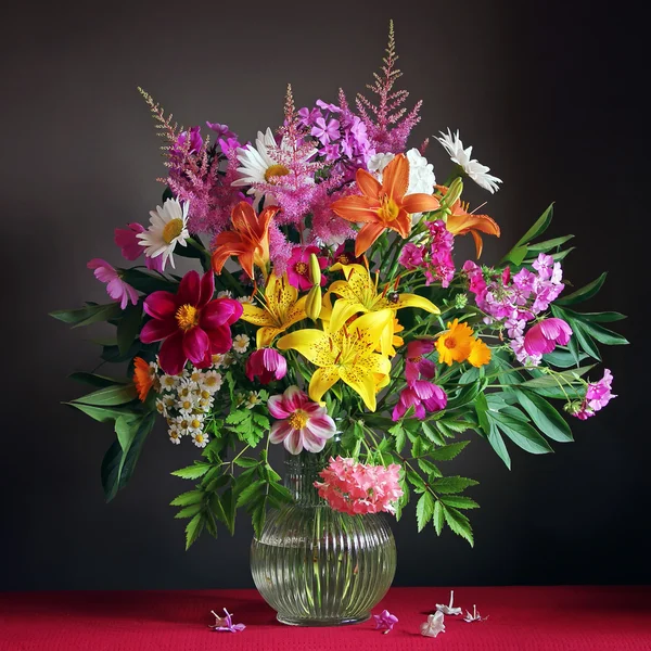 Still life with a bouquet of lilies and camomiles. — Stock Photo, Image