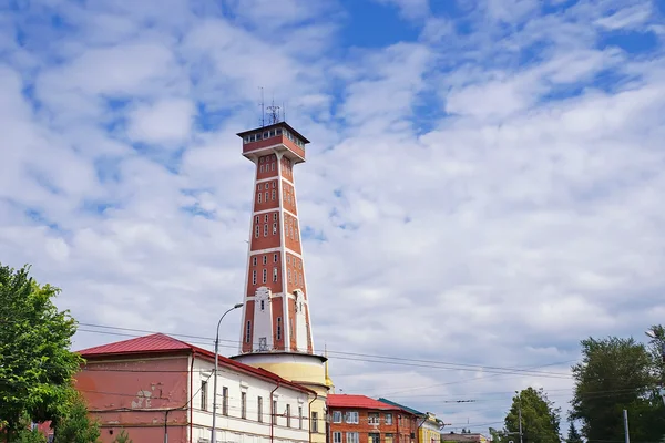 Fire tower against the blue sky with clouds. — Stock Photo, Image